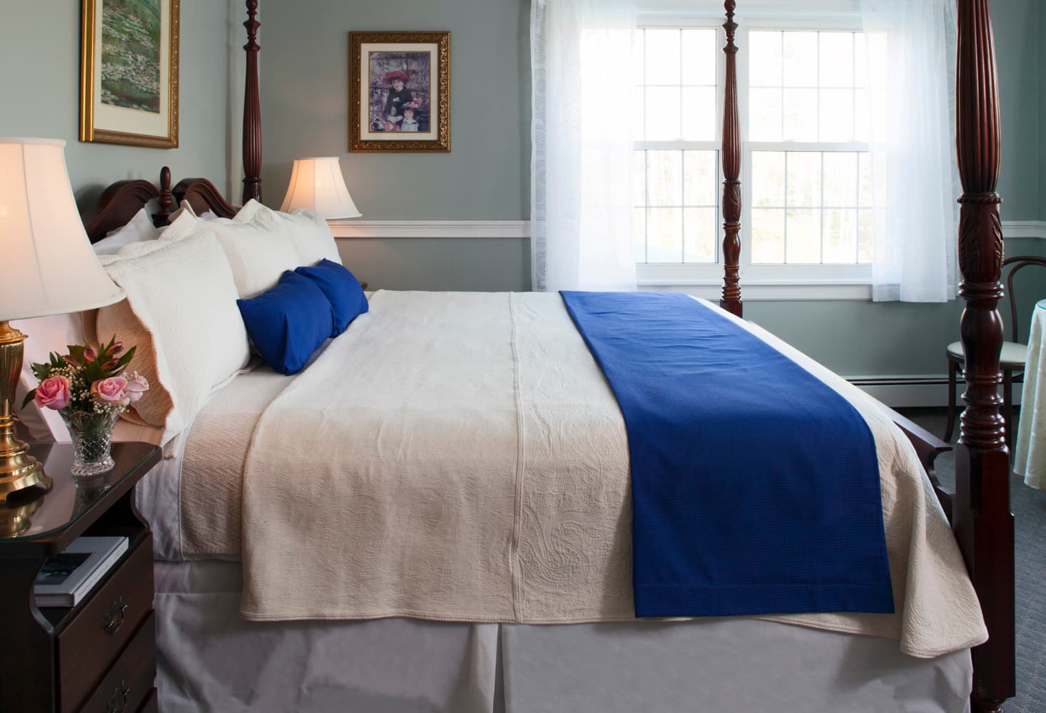 The 4 poster king bed in the bedroom with window.