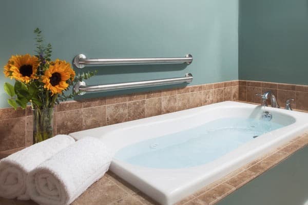 The one person spa tub with safety bars installed to assist with entering and exiting the tub.