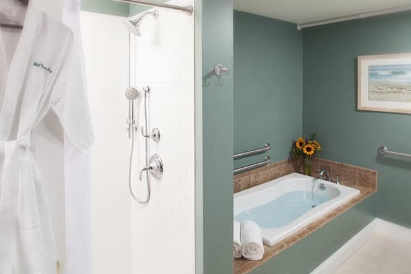 The bathroom's spa tub and shower stall with robe provided for guest use.