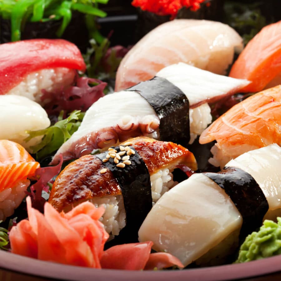 A vibrant assortment of sushi pieces garnished with wasabi and pickled ginger.