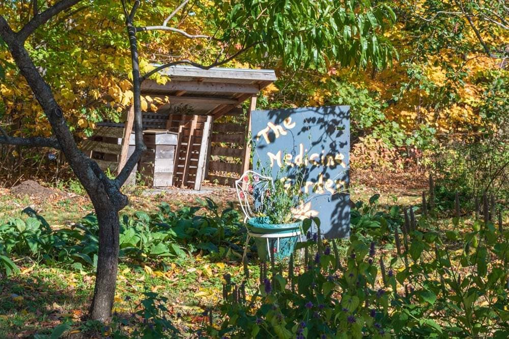 A garden featuring a sign that reads "The Medicinal Garden" amidst colorful autumn foliage.