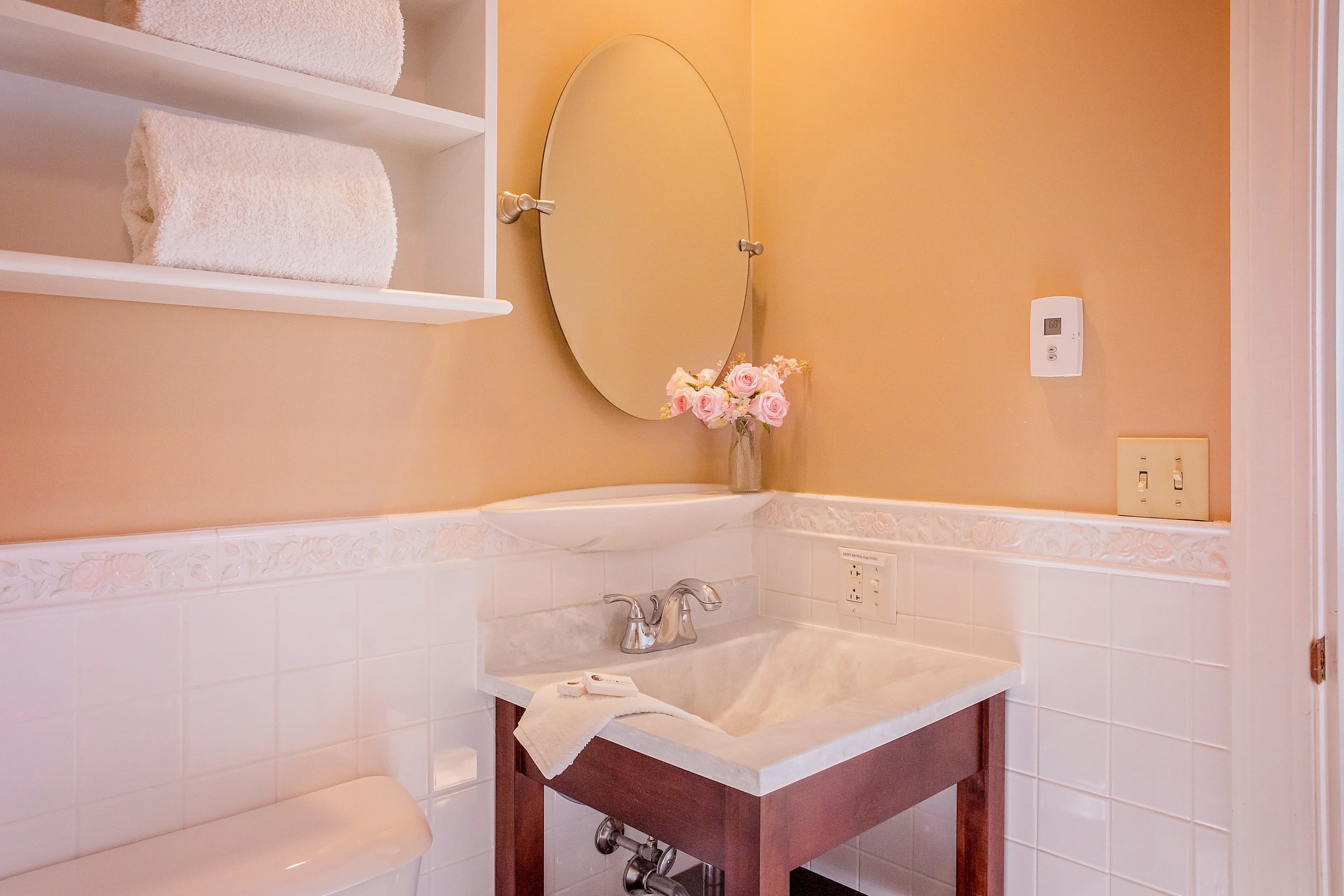The wooden vanity, sink and mirror in the bathroom.