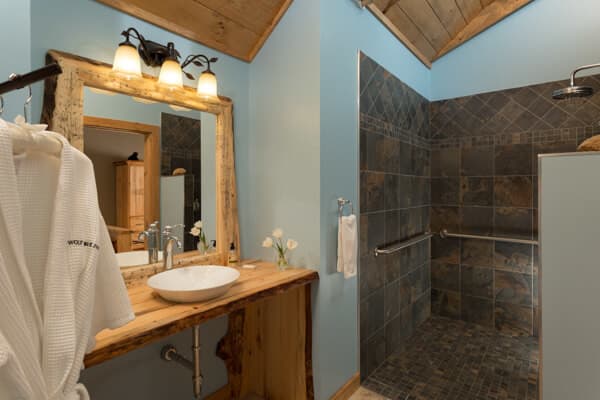View of the "roll under" pine vanity and "roll in" tiled shower with safety bars.