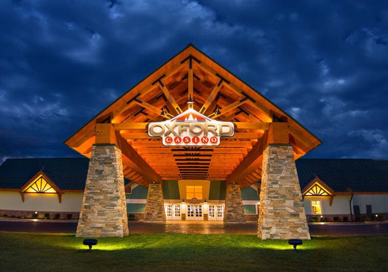 Entrance of Oxford Casino illuminated at night under a dramatic sky.