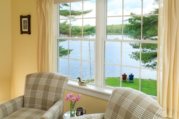 Closeup view of the comfortable chairs in the bedroom set by the large window overlooking Tripp Lake.