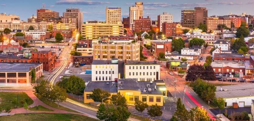 Aerial view of a vibrant city skyline featuring a mix of modern and historic buildings at sunset.