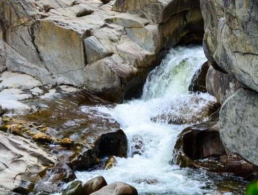 A small waterfall cascades between rocky formations.