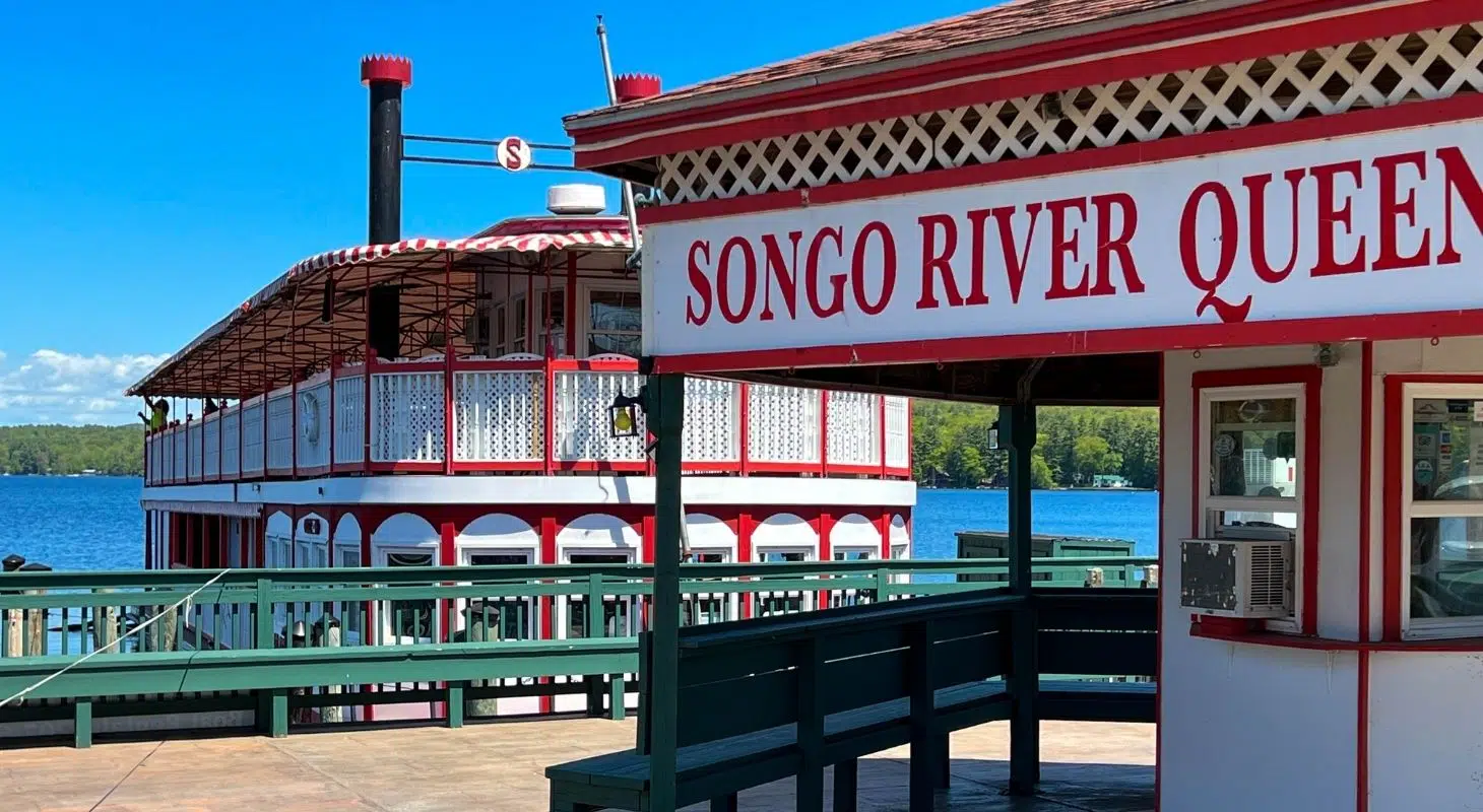 View of the Songo River Queen boat from a dock with a clear blue sky.