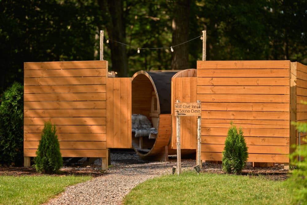 A wooden sauna oasis with pathway and greenery in a serene outdoor setting.