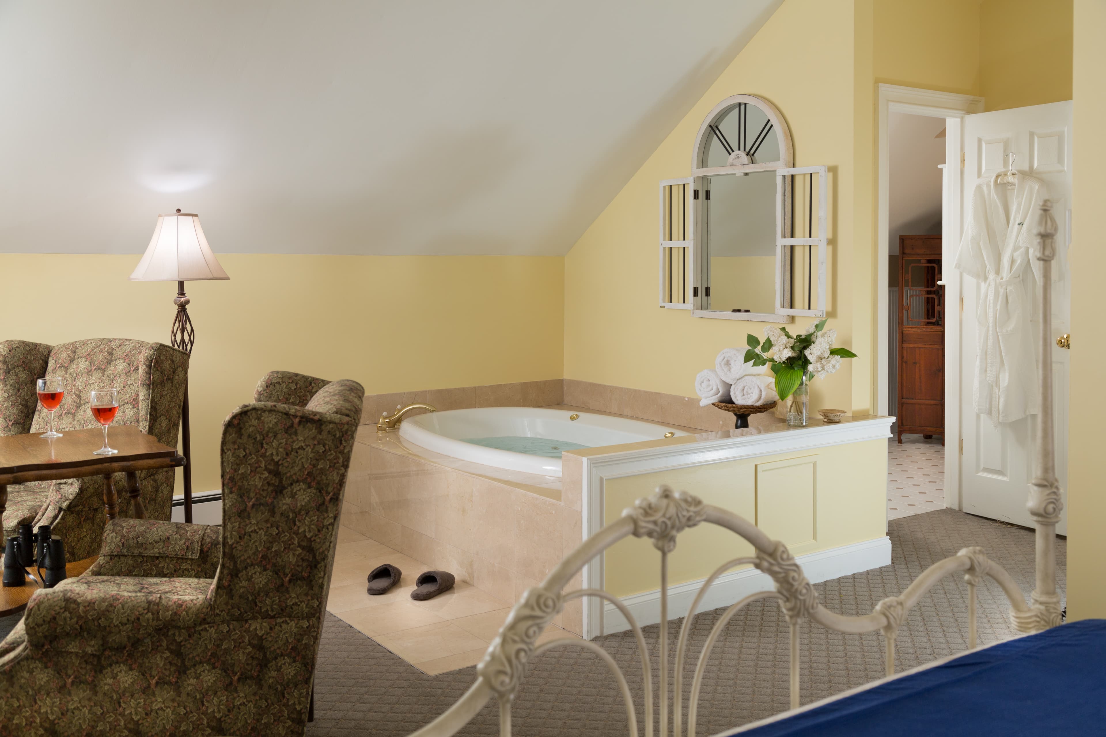 The large, 2 person spa tub with mirror showing that the bathroom is just behind the wall.