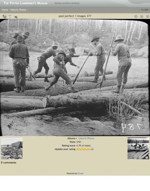 Black and white photo of workers logging by a river, manipulating large logs with tools.