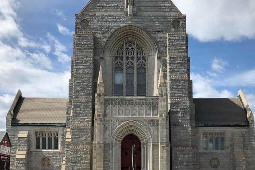 A stone church facade features intricate architectural details and a large central entrance.