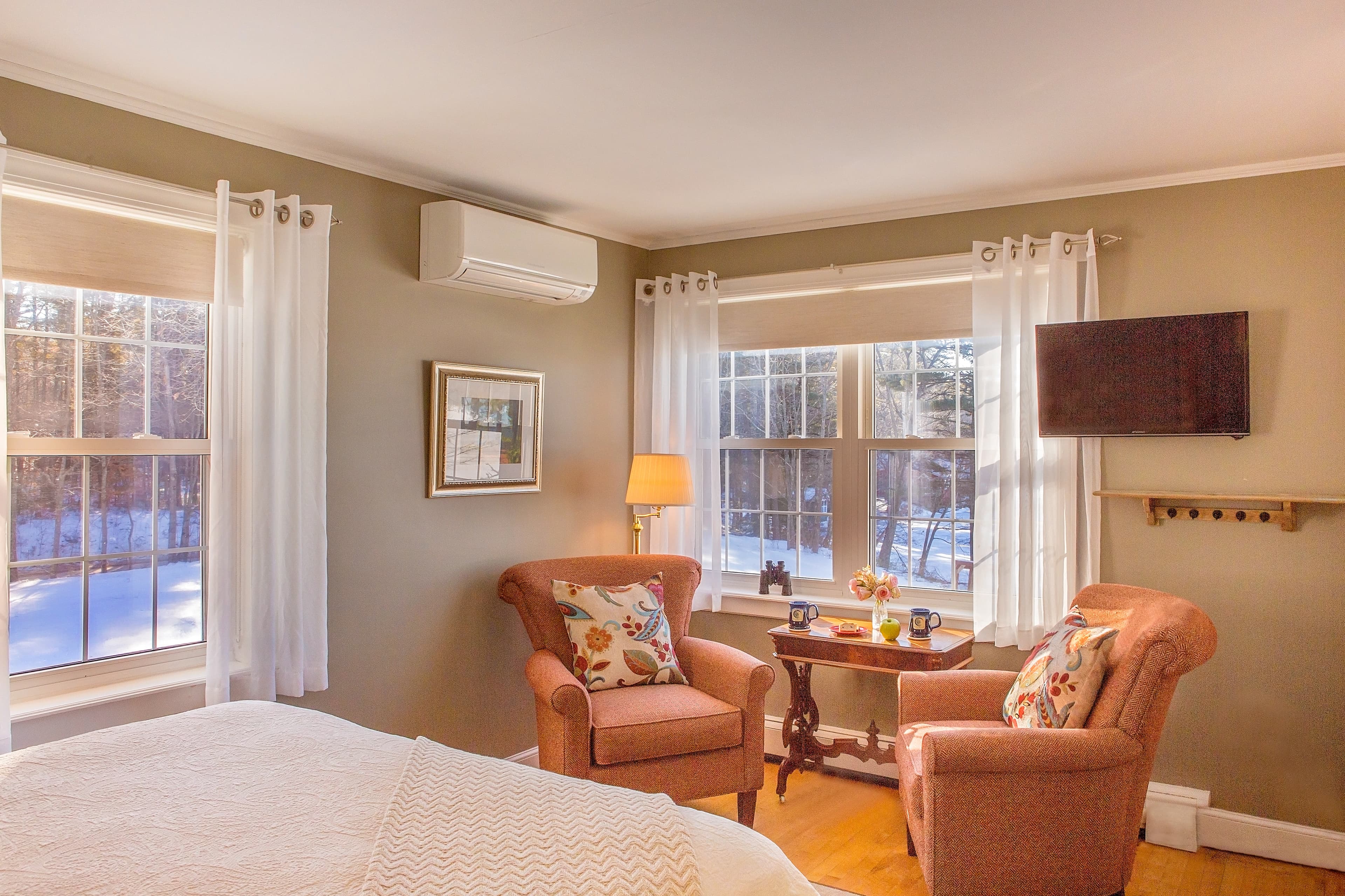 The comfortable chairs set by the large window overlooking Tripp lake.