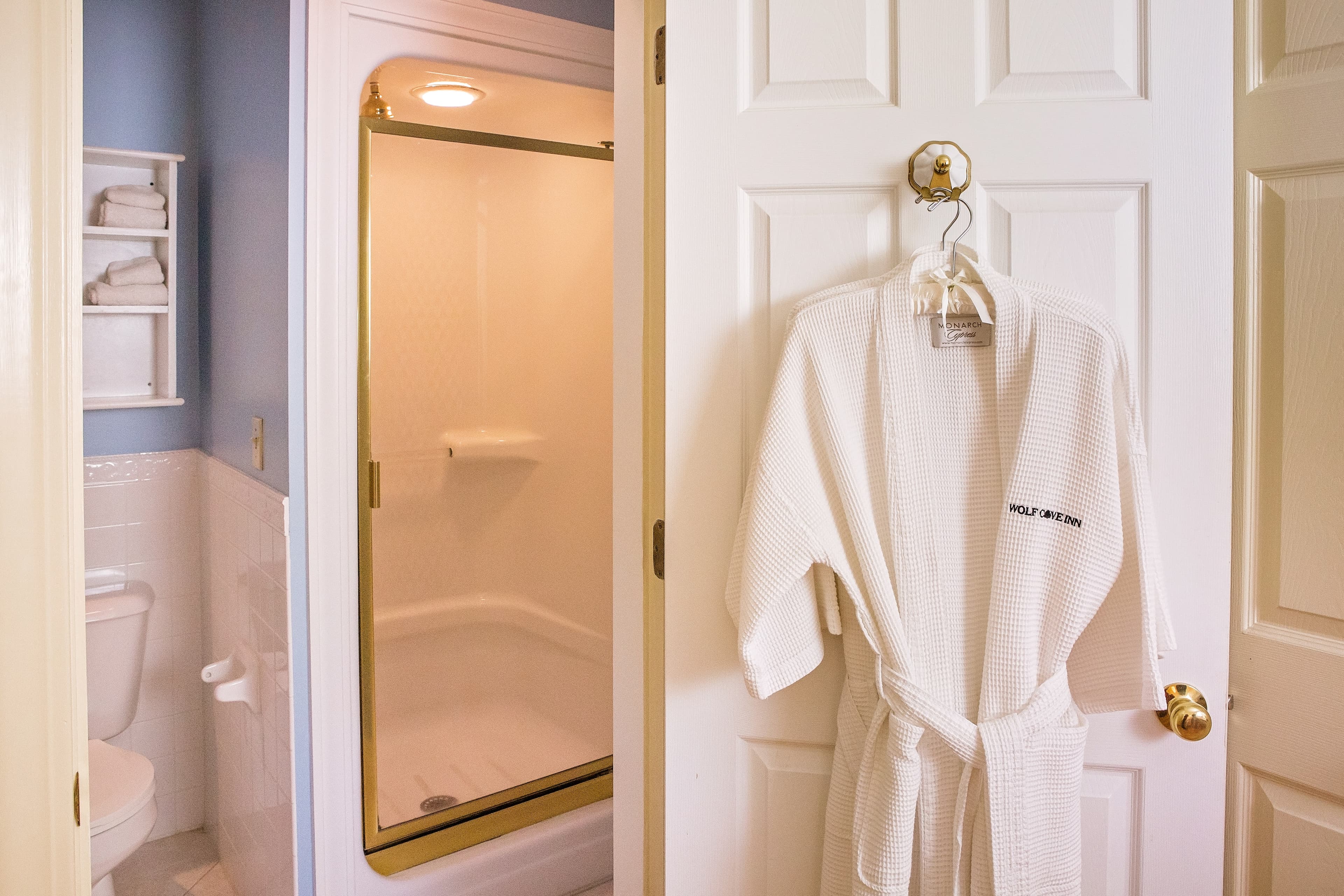 The stall shower in the bathroom and the robe provided for guest use.