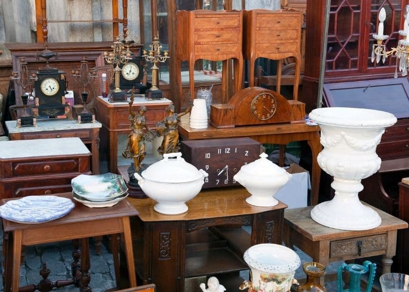 A collection of vintage furniture and decor items, including clocks, vases, and decorative dishware.