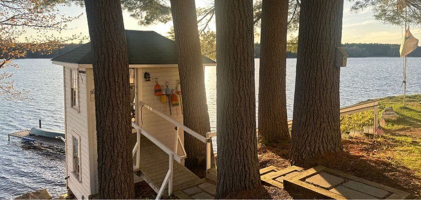 boathouse bistro and dock on the shore of tripp lake with sun setting in the background