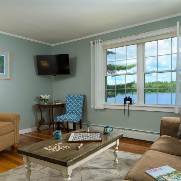 Sitting area with board games and coffee mugs out by television and large window