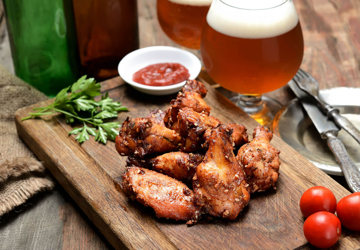 Artisan hot wings on plate with sauces and beer