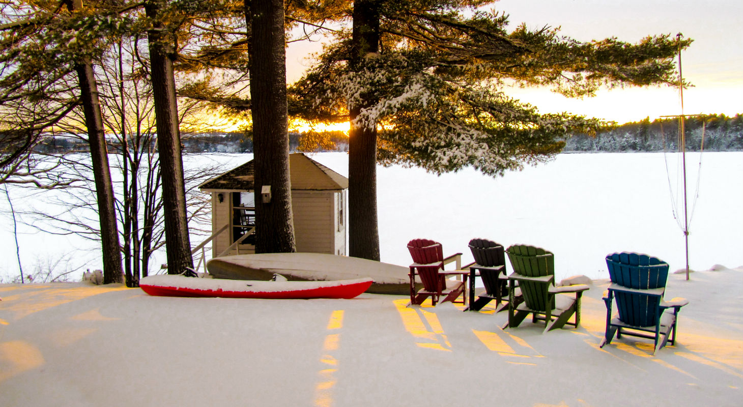 Sunset over snowy lake with chairs