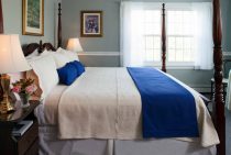 Soft antique bed with white sheets and pillows and blue accents