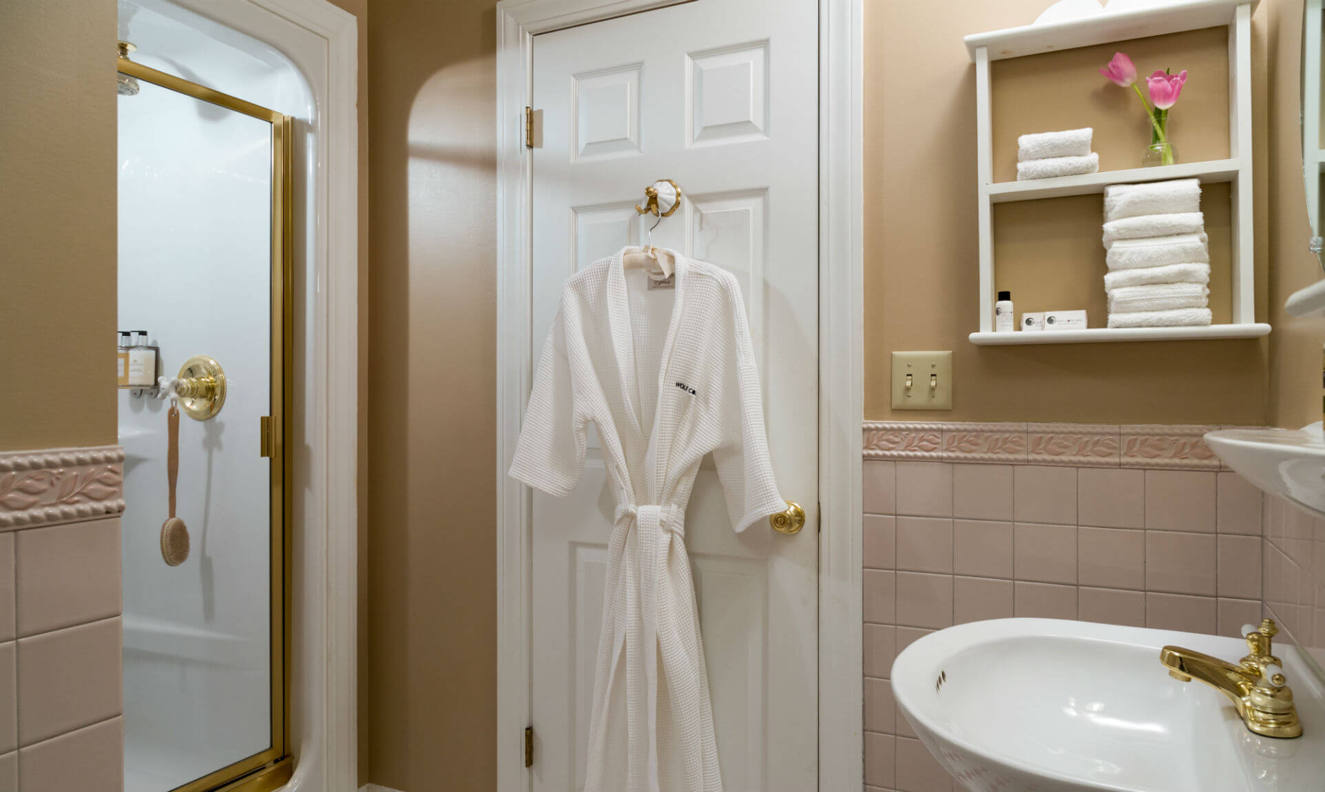 Soft bathrobe next to shower and sink in the Penobscot Bay room