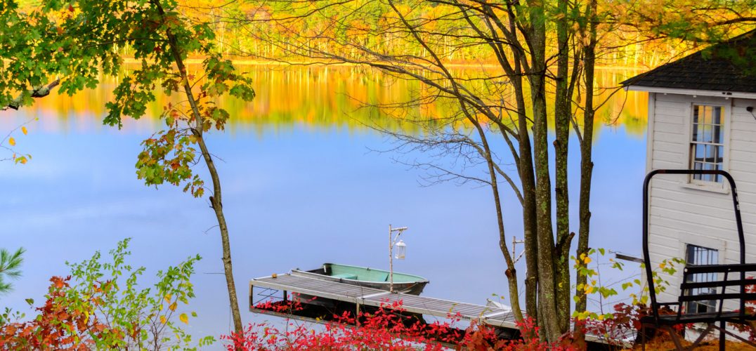 lake surrounded by red, orange, and yellow fall foliage