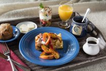 French Toast on a blue plate with coffee and orange juice.