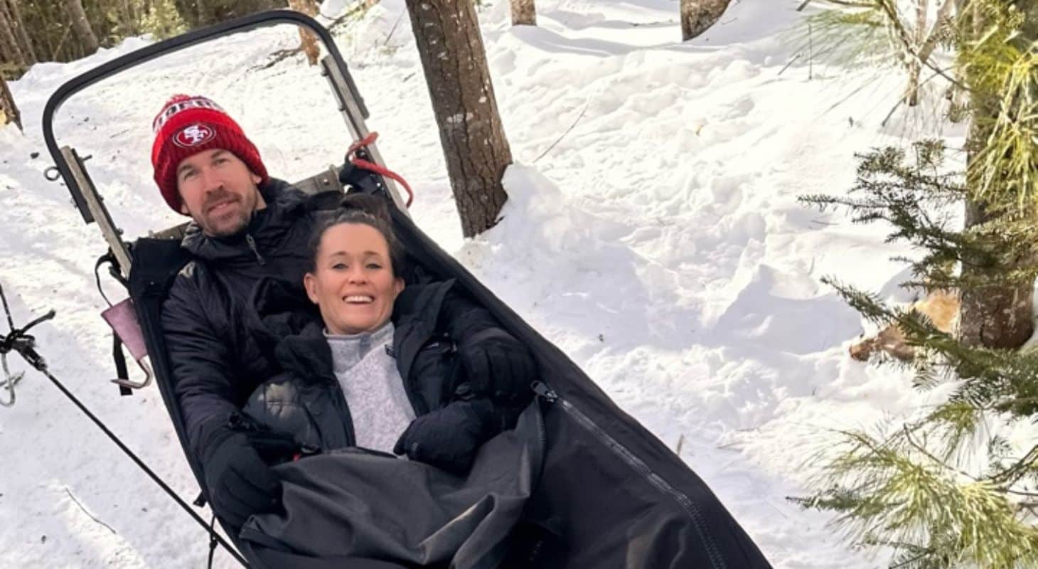 geoff and nicole skidmore, owners of wolf cove inn, on a dog sledding adventure