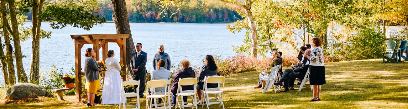 Small wedding ceremony by a lake in the fall