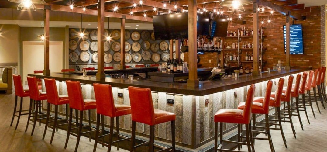 Oxford Casino bar with red bar stools and shelves of bottles