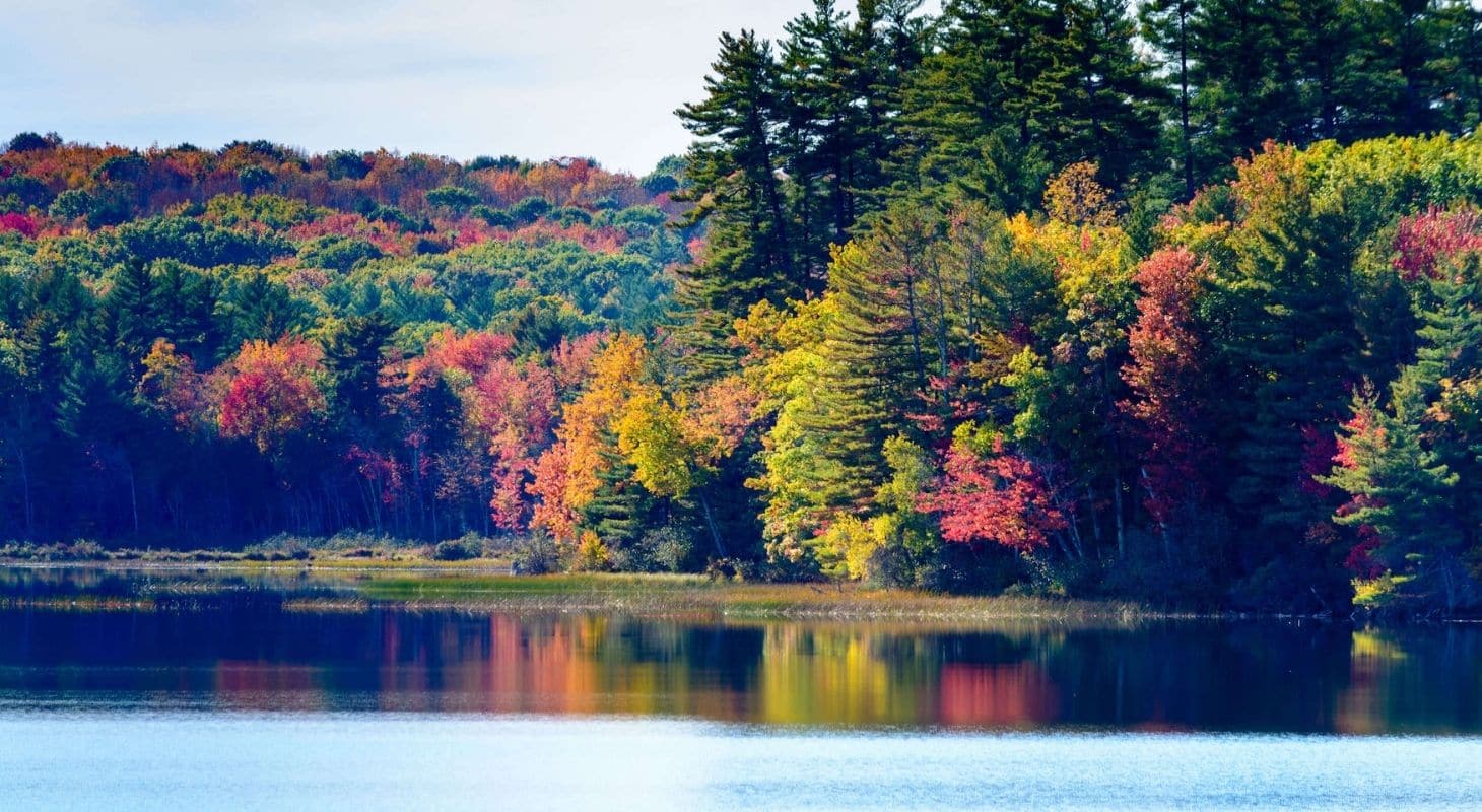 Reds, yellows and oranges of fall foliage reflecting on the surface of a lake