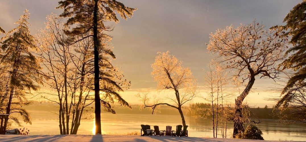 Sunset after an ice storm with chairs by a lake