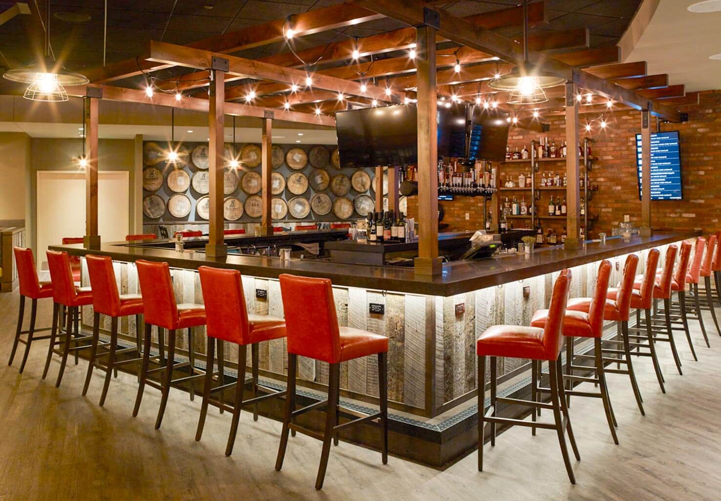 Red bar stools around a wooden themed bar area