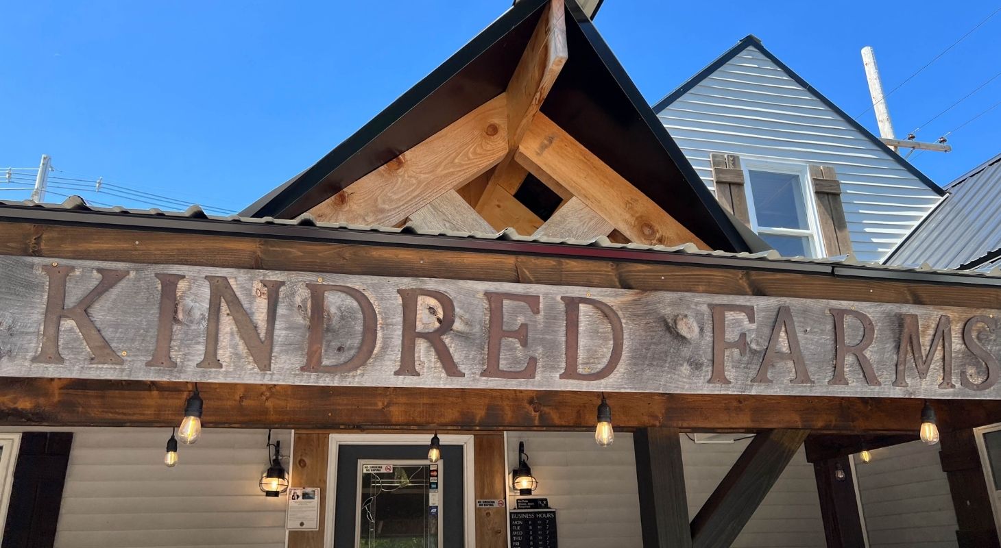 Close up view of Kindred Farms Market & Bakery sign made of wood