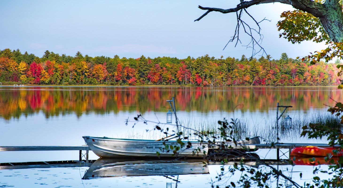 Fishiing boat on Tripp Lake surrounded by brilliant fall foliage