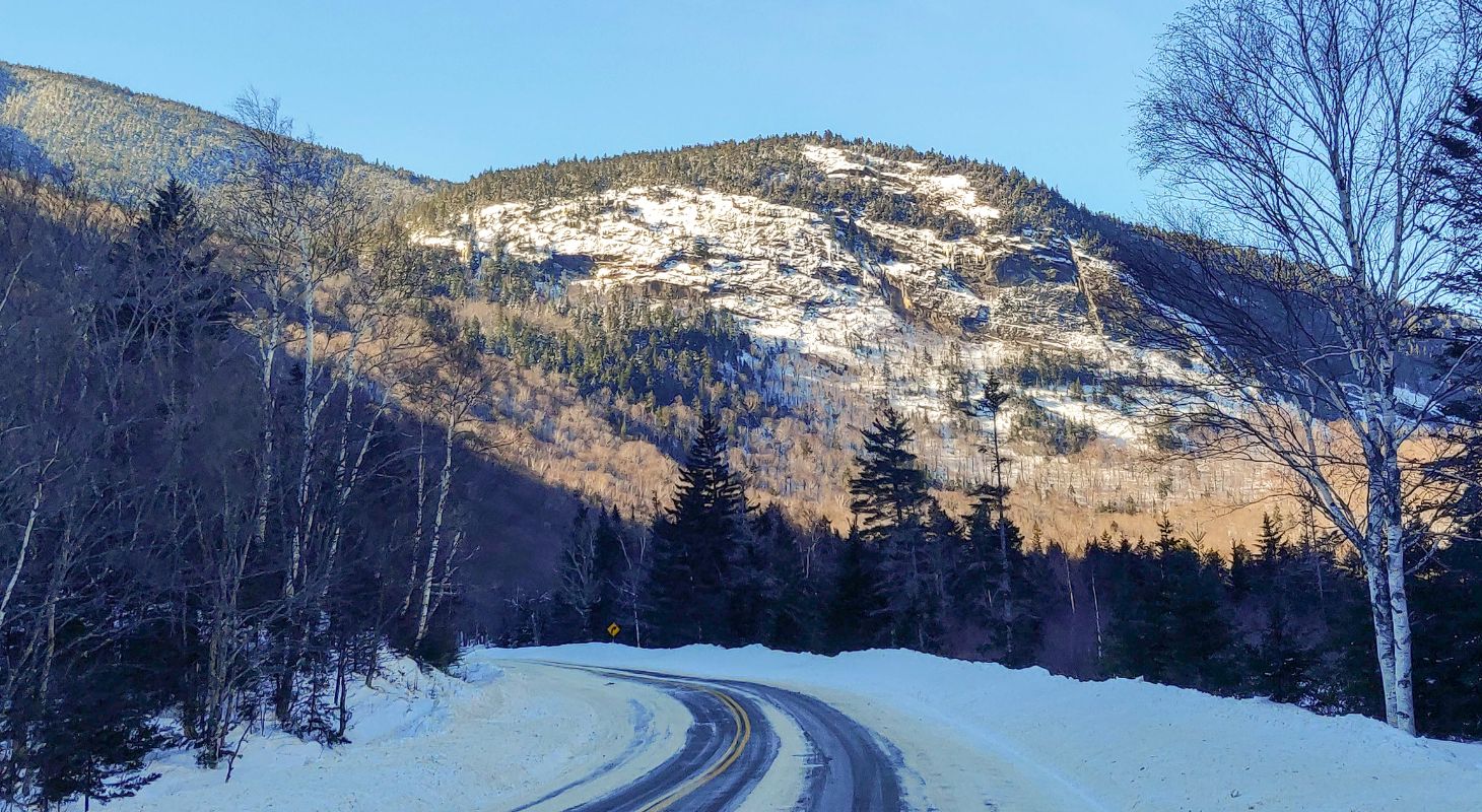 A snowy road leading to the mountains at Grafton Notch State Park in Maine.