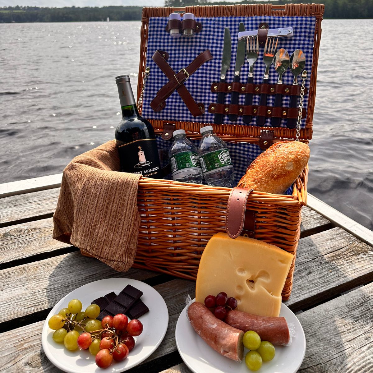 picnic basket with wine, water, grapes, chocolate, bread, and cheese