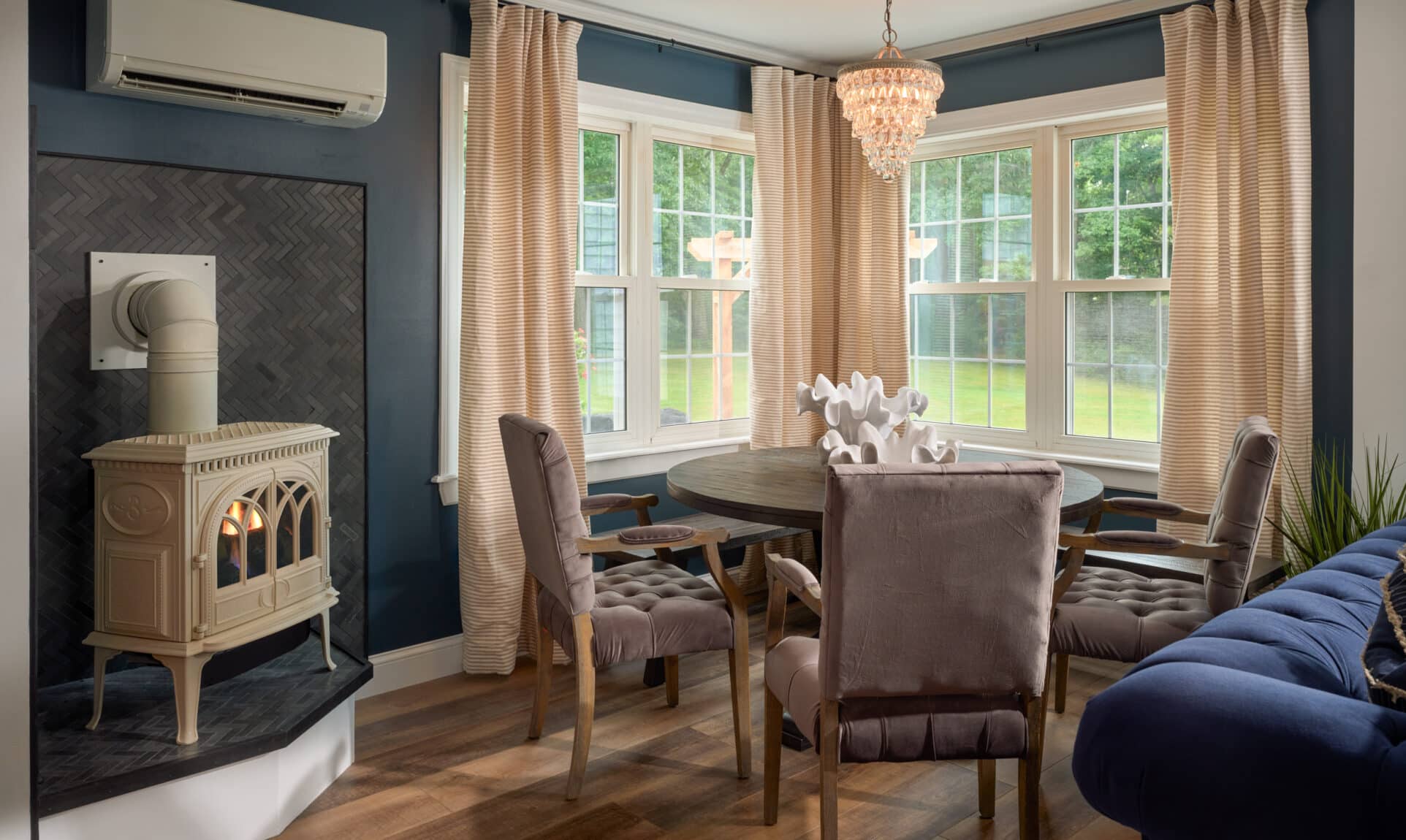 Dining Room and gas fireplace with a view of gardens, lawn and lake