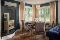 Dining Room and gas fireplace with a view of gardens, lawn and lake