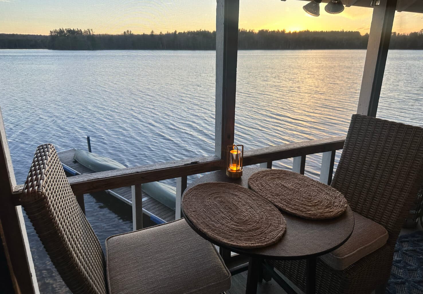 A dining room table and chairs for two overlooking a lake