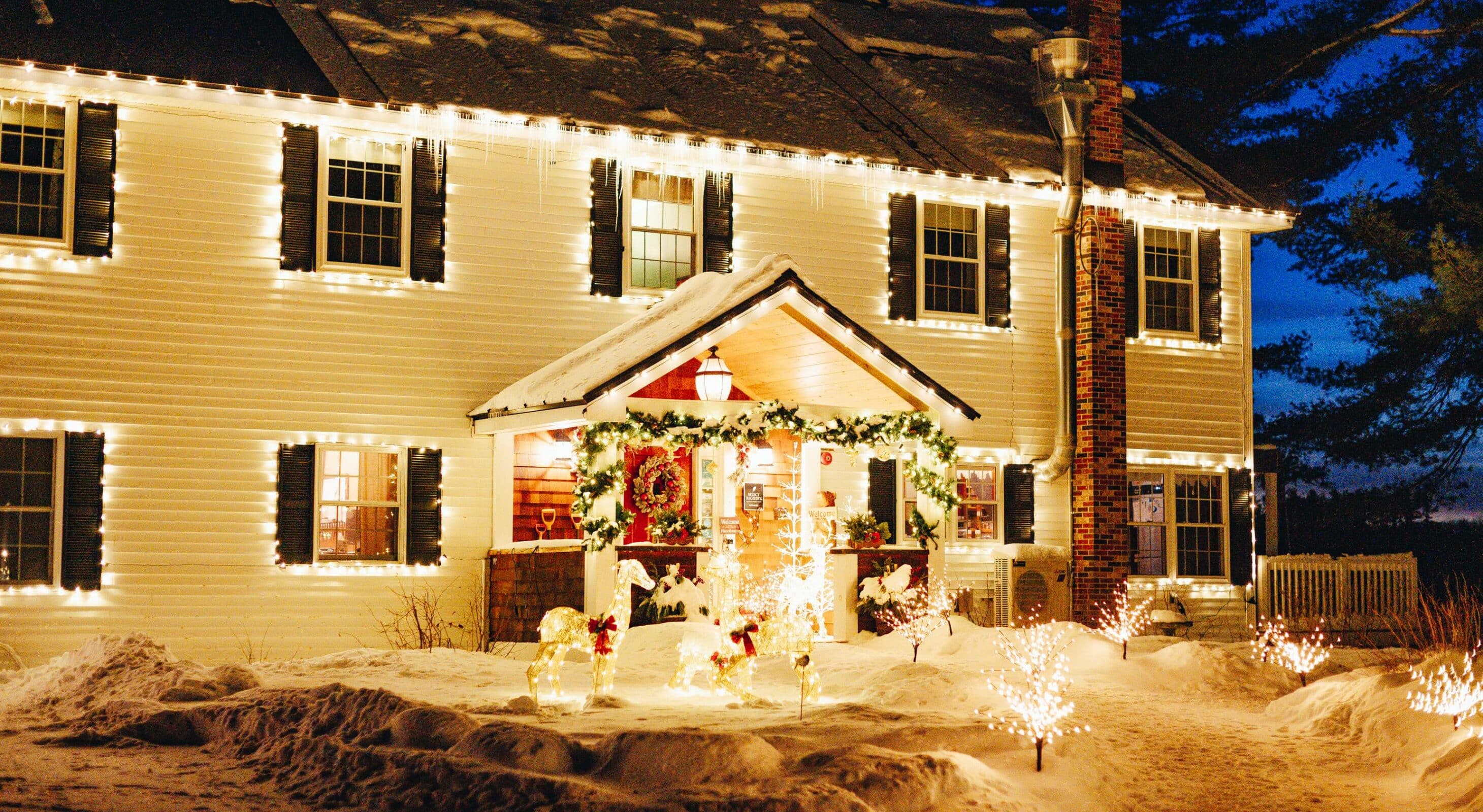 The front of a festively decorated Wolf Cove Inn after a snow storm