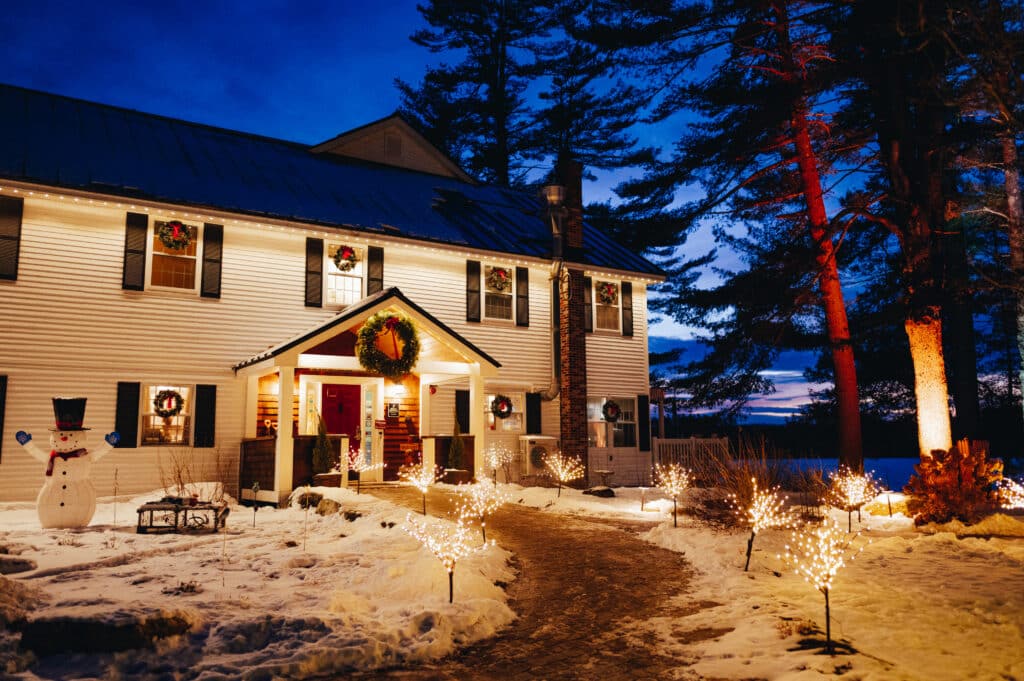 A photo of a wintery festive Wolf Cove Inn after sunset